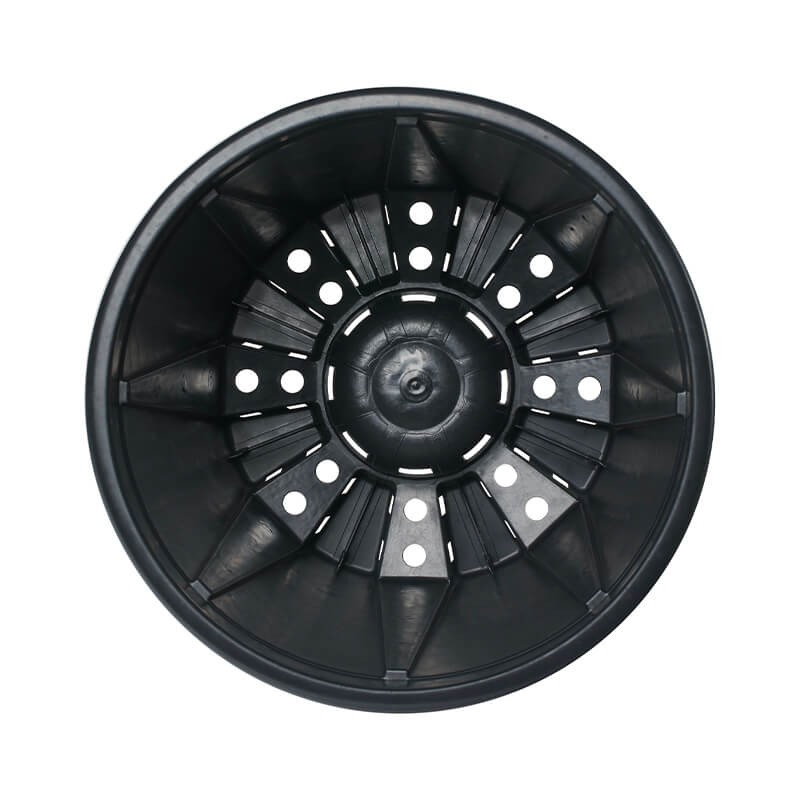 Top-down view of interior of black plastic pot with drainage holes