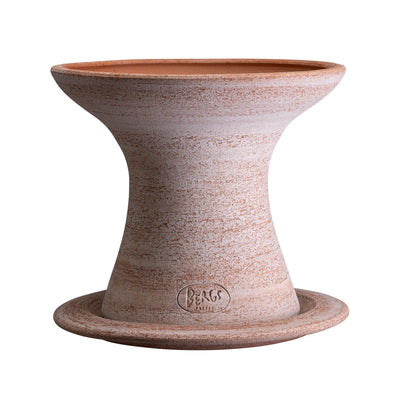 Raw terracotta Bergs Potter planter sitting on matching saucer with a textured surface on a white background